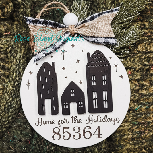 Decorative ornament with houses and 'Home for the Holidays 85364' text on a green textured background.