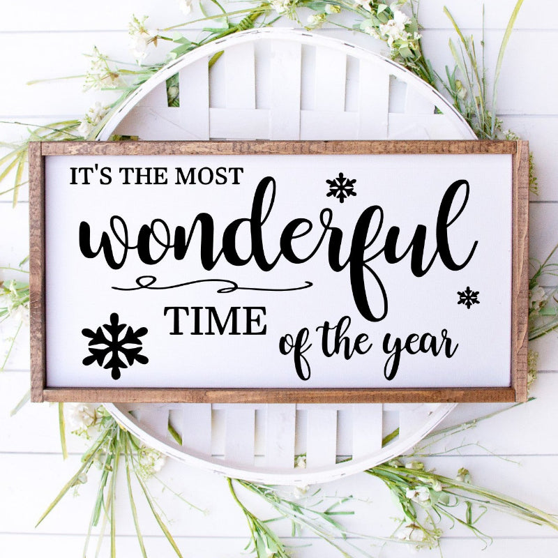 Decorative sign with 'It's the most wonderful time of the year' text on a white background with greenery.