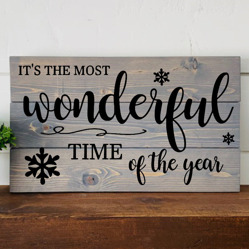 Wooden sign with 'It's the most wonderful time of the year' text on a wooden surface.