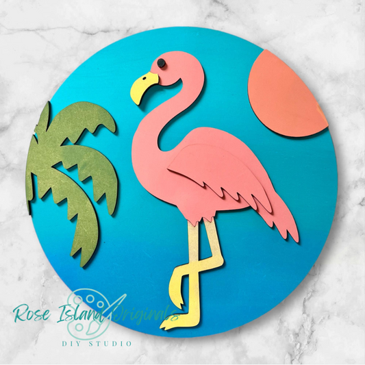 Wood cutout of a pink flamingo and palm trees on a blue circle with 'Rose Island Originals' branding.