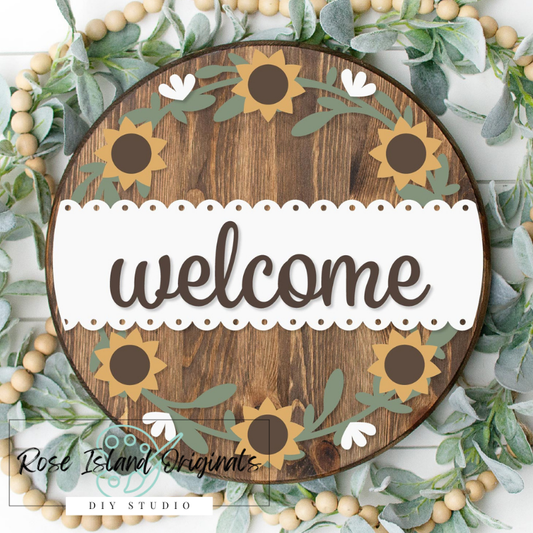 Round wood sign with sunflowers and greenery around border with word welcome on white scalloped background